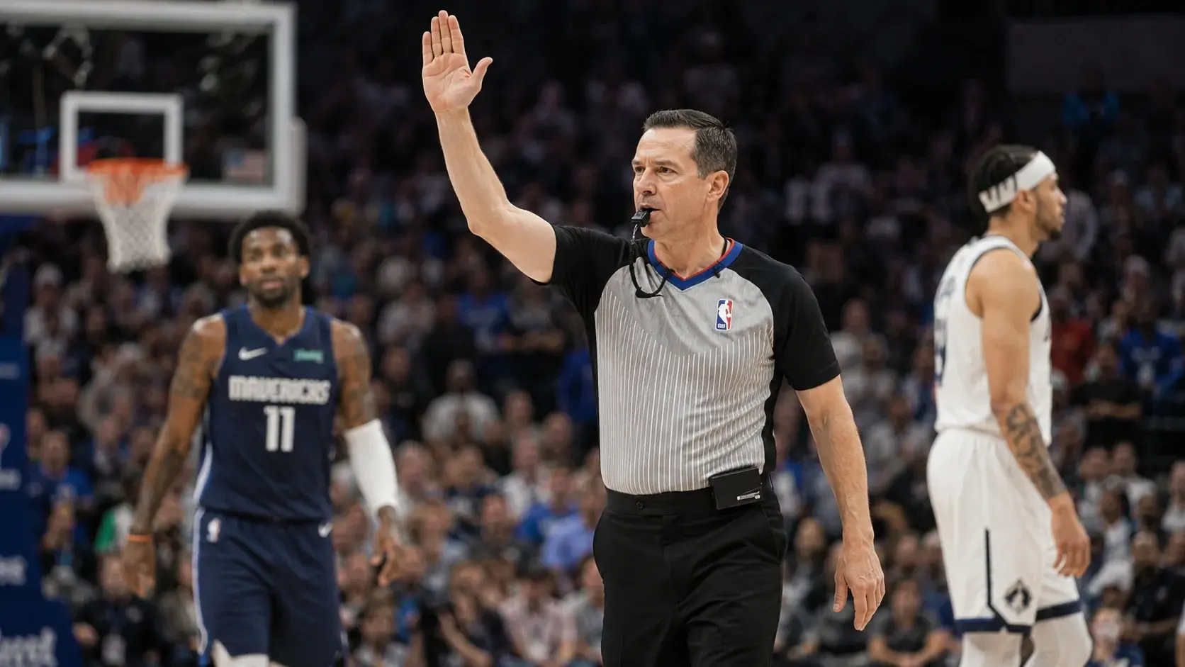 NBA referee blowing his whistle to make a foul call during a professional basketball game
